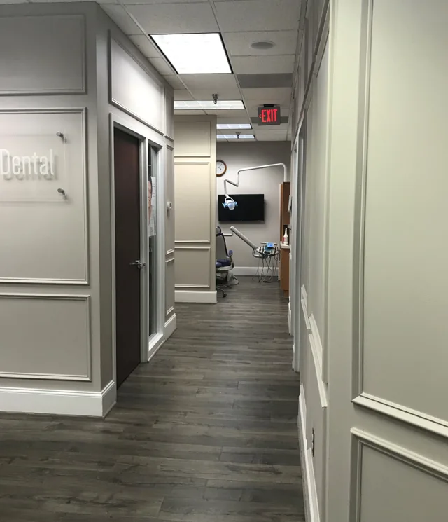 Office hallway with soft gray walls, white paneling and wood-look floors