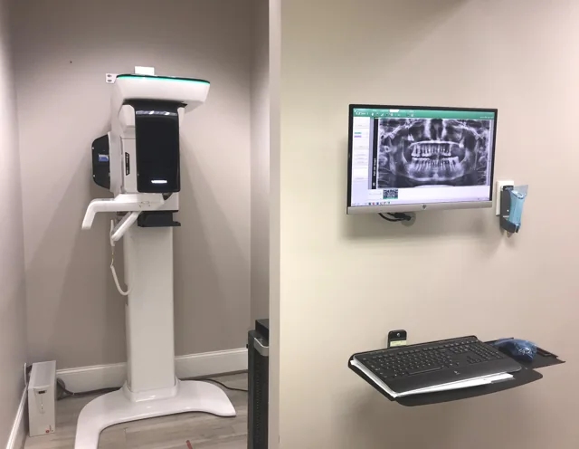 Dental imaging equipment and a wall-mounted computer displaying a dental X-ray